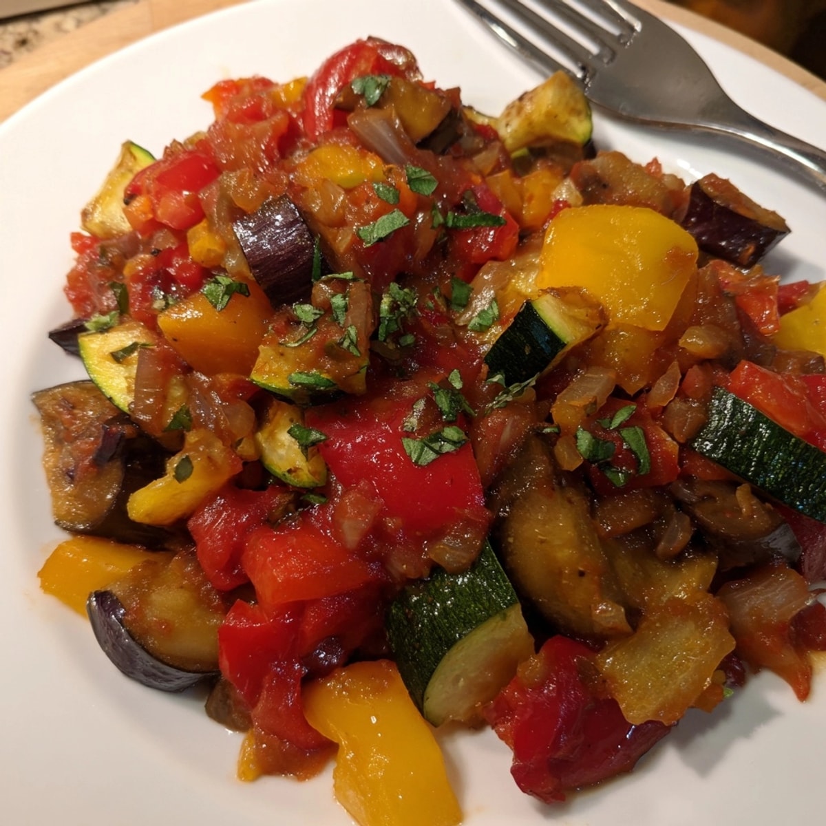 A flavorful spoonful of Easy Ratatouille, highlighting the colorful mixture of summer vegetables.