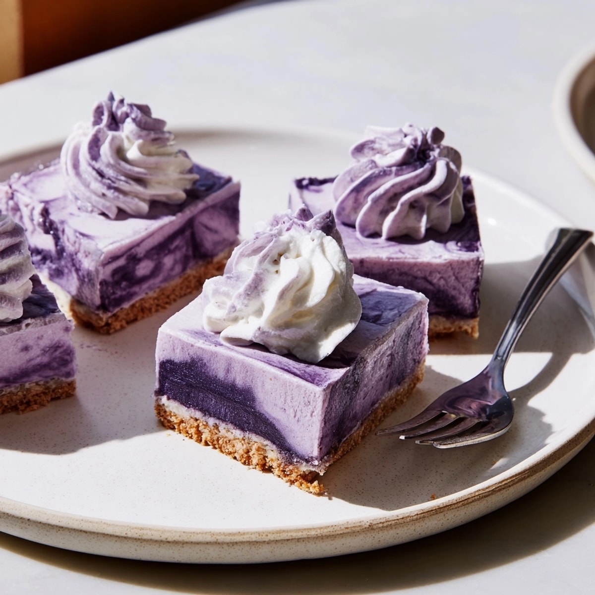 Buttery graham cracker crust topped with creamy homemade Ube Cheesecake Bars; bake until set.