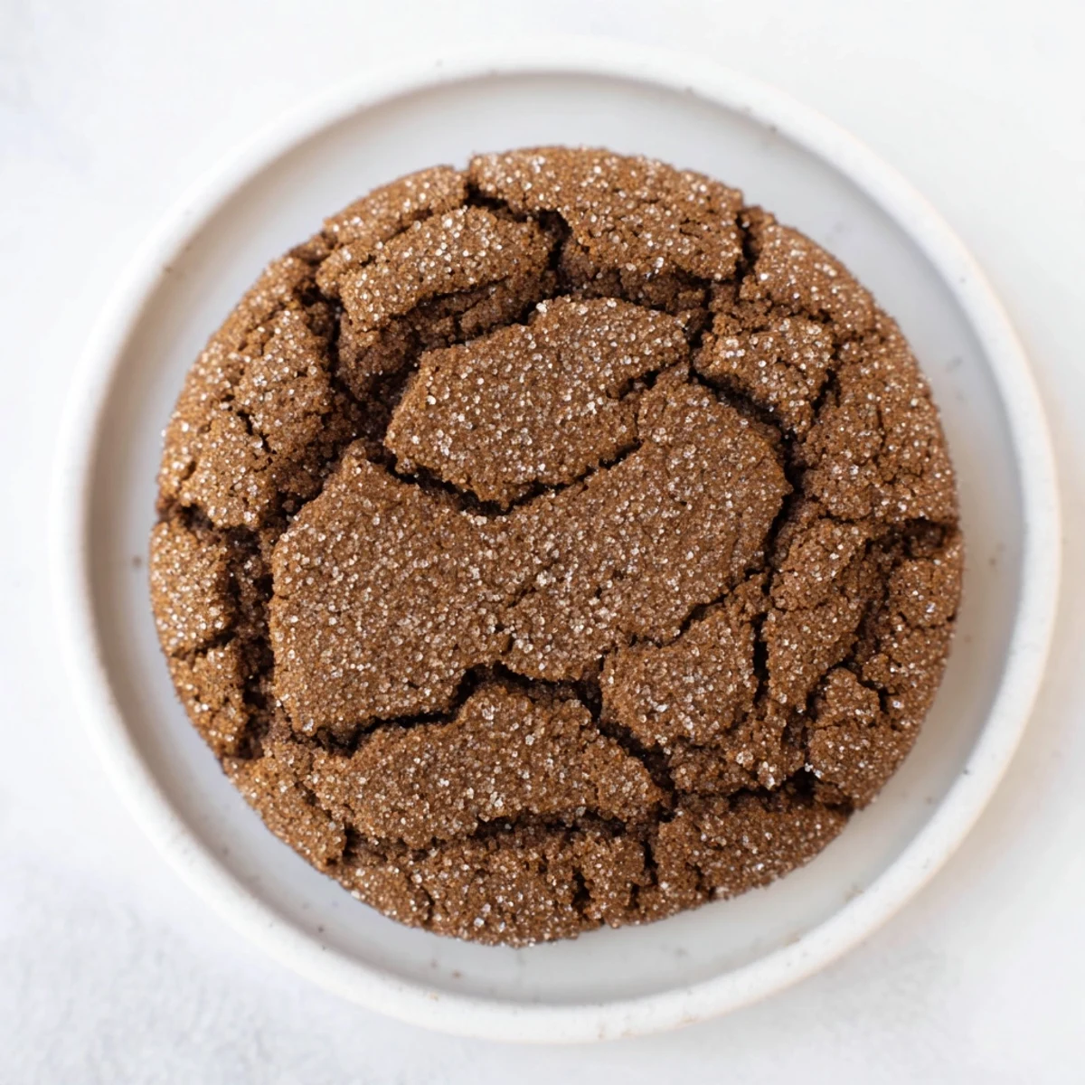 Warm, fragrant Spiced Molasses Crinkle Cookies, ready to eat alongside a steaming cup of tea.