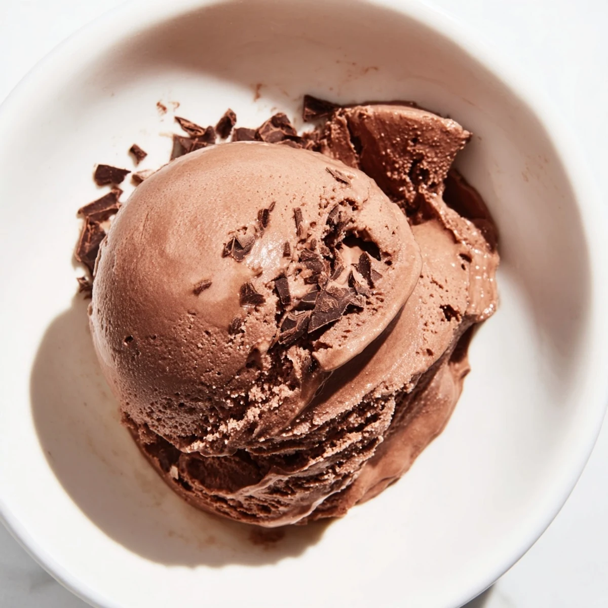 A scoop of rich chocolate ice cream, swirled with texture and ready to enjoy as a sweet treat.