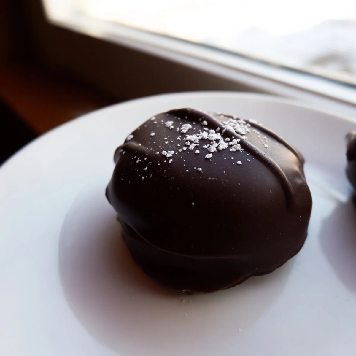 A close-up shot of creamy, minty peppermint patties, dipped in glossy dark chocolate, perfect treat.