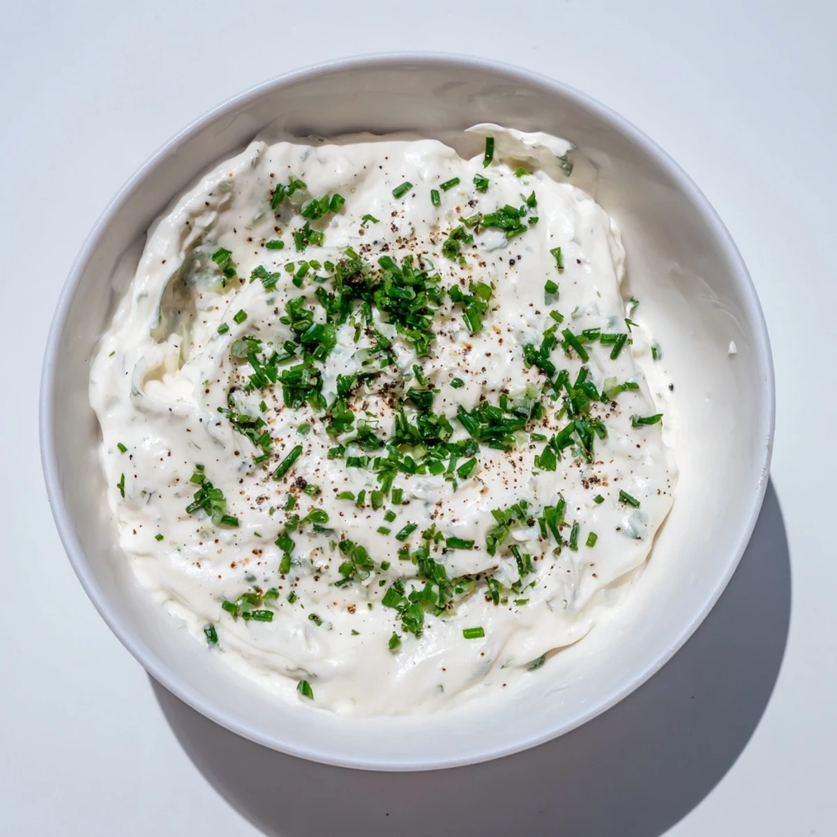 Close-up of a flavorful garlic dip, showcasing fresh herbs and a smooth, appealing texture.