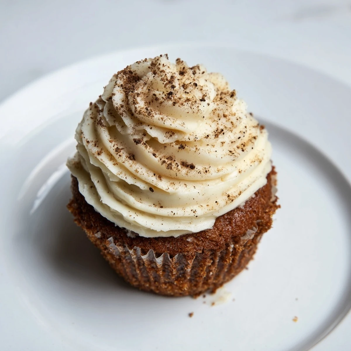 Warmly spiced gingerbread cupcakes, freshly baked and topped with smooth, sweet vanilla frosting.