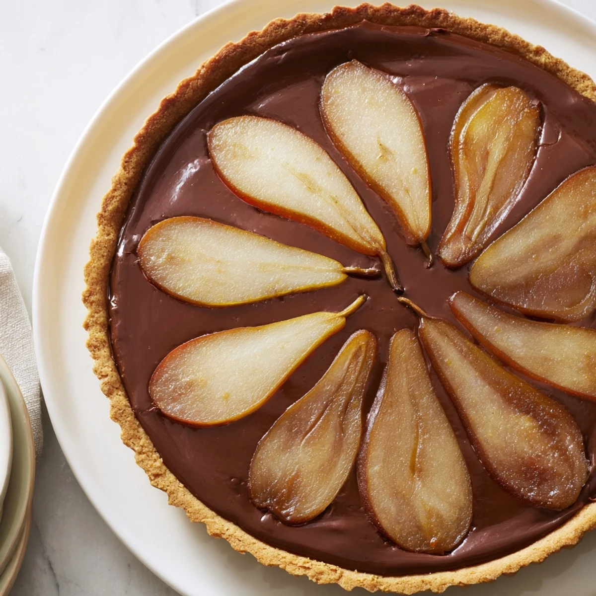 Warm, glistening slices of the Warm Pear and Chocolate Tart beautifully arranged on a plate.
