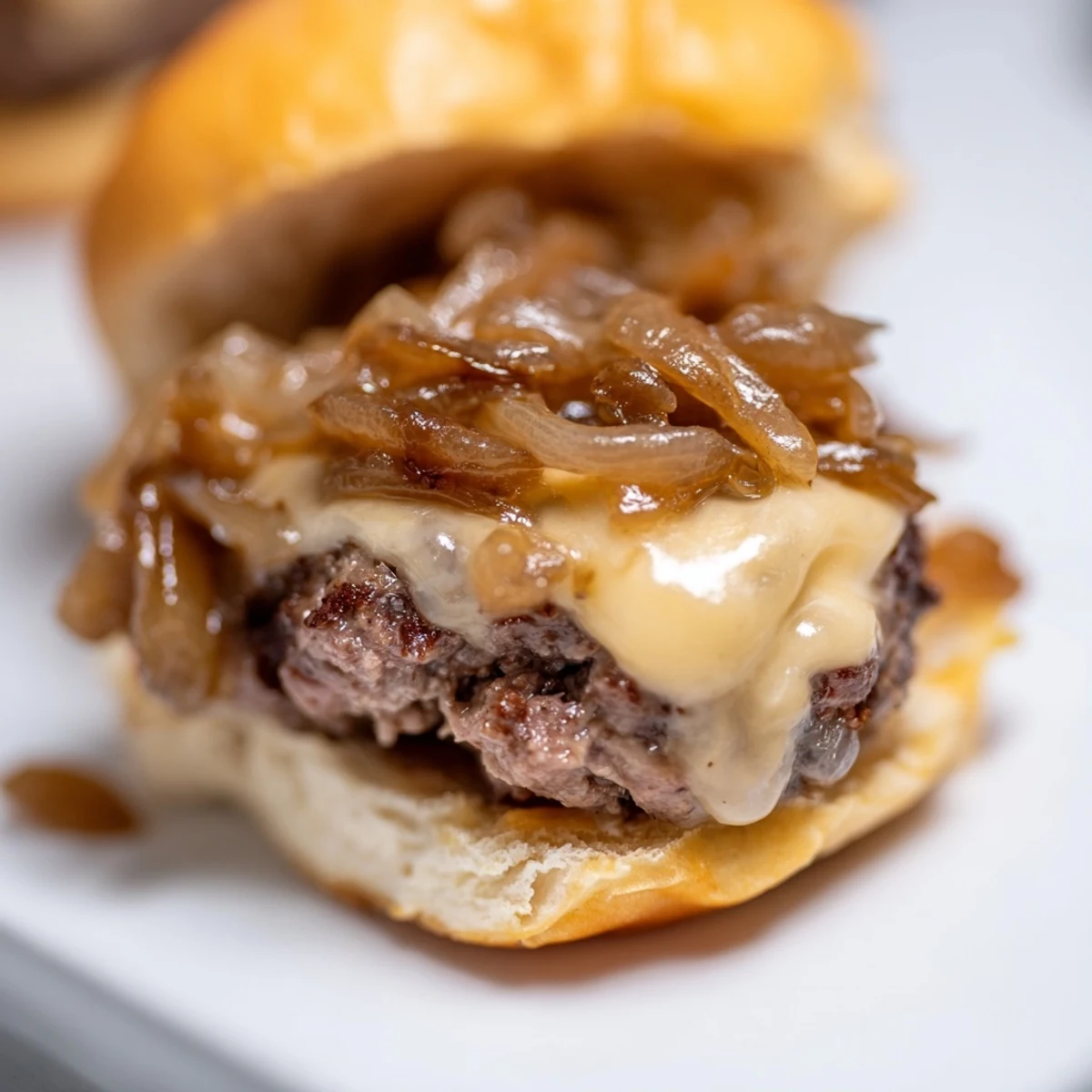 Mini beef patties with sweet caramelized onions on soft buns, perfect for parties or a quick meal.