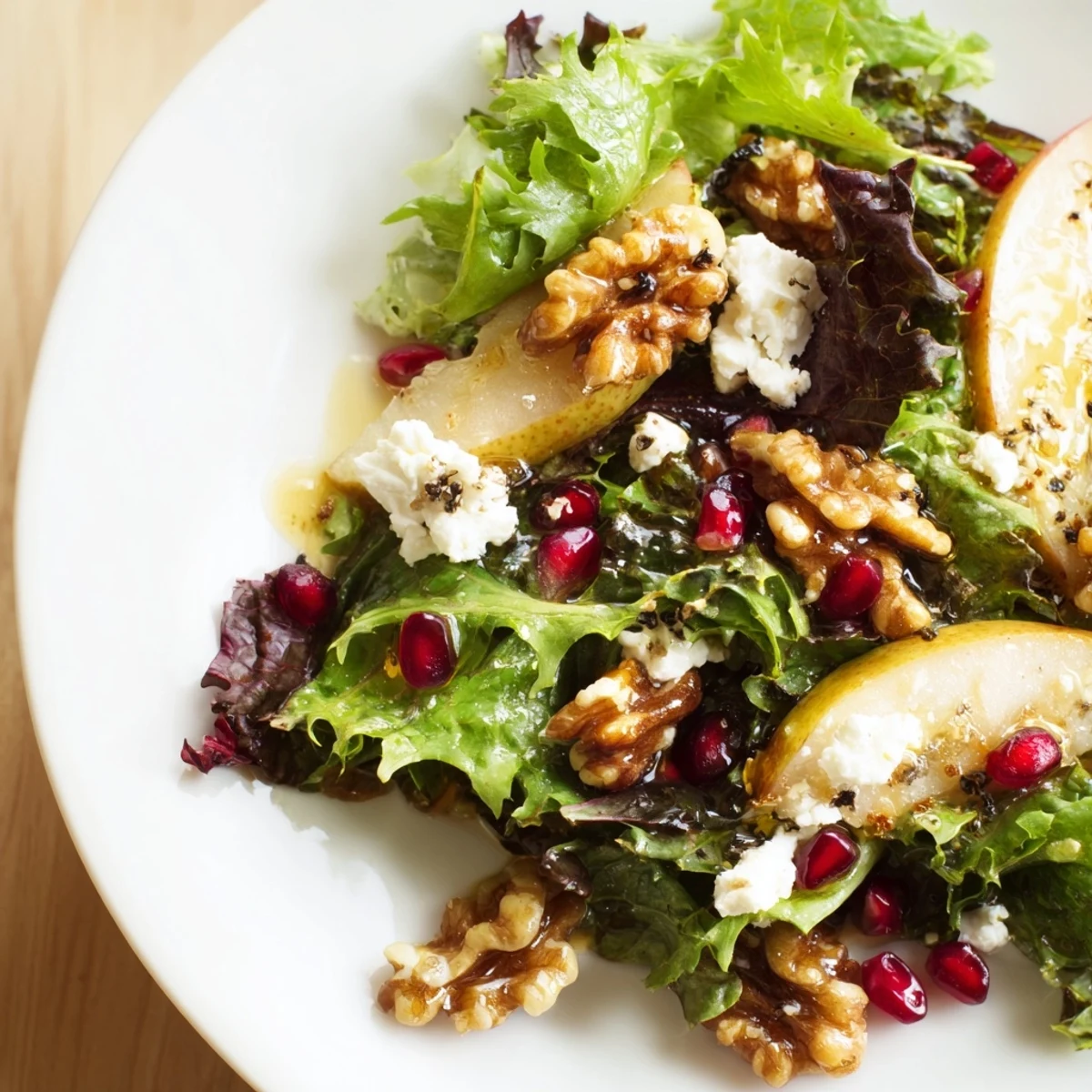 Overhead view of Winter Green Salad with Pear and Walnuts tossed in a tangy vinaigrette, ready to serve as a fresh side.