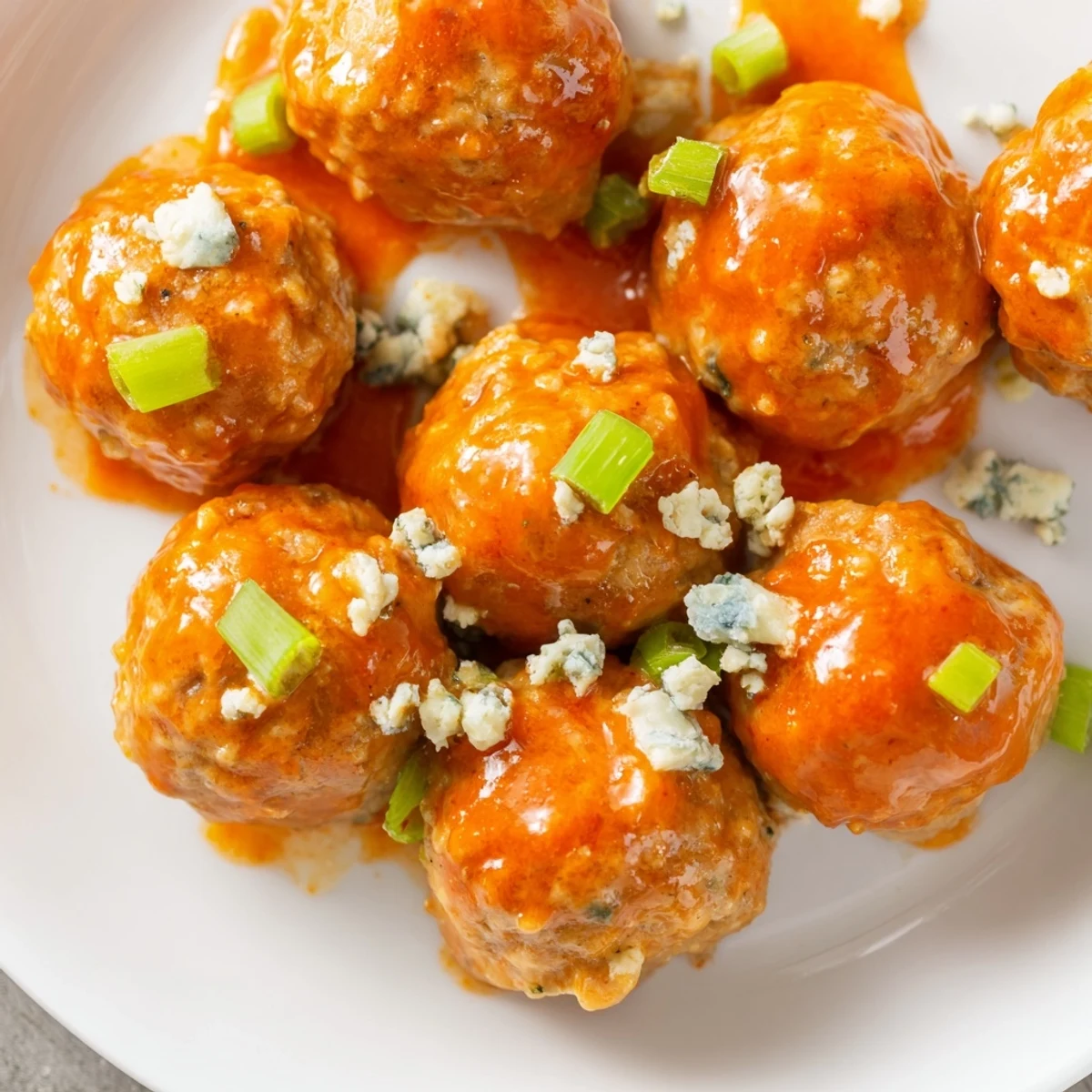Freshly baked Touchdown Buffalo Chicken Meatballs piled high, ready for a game day snack with blue cheese crumbles.