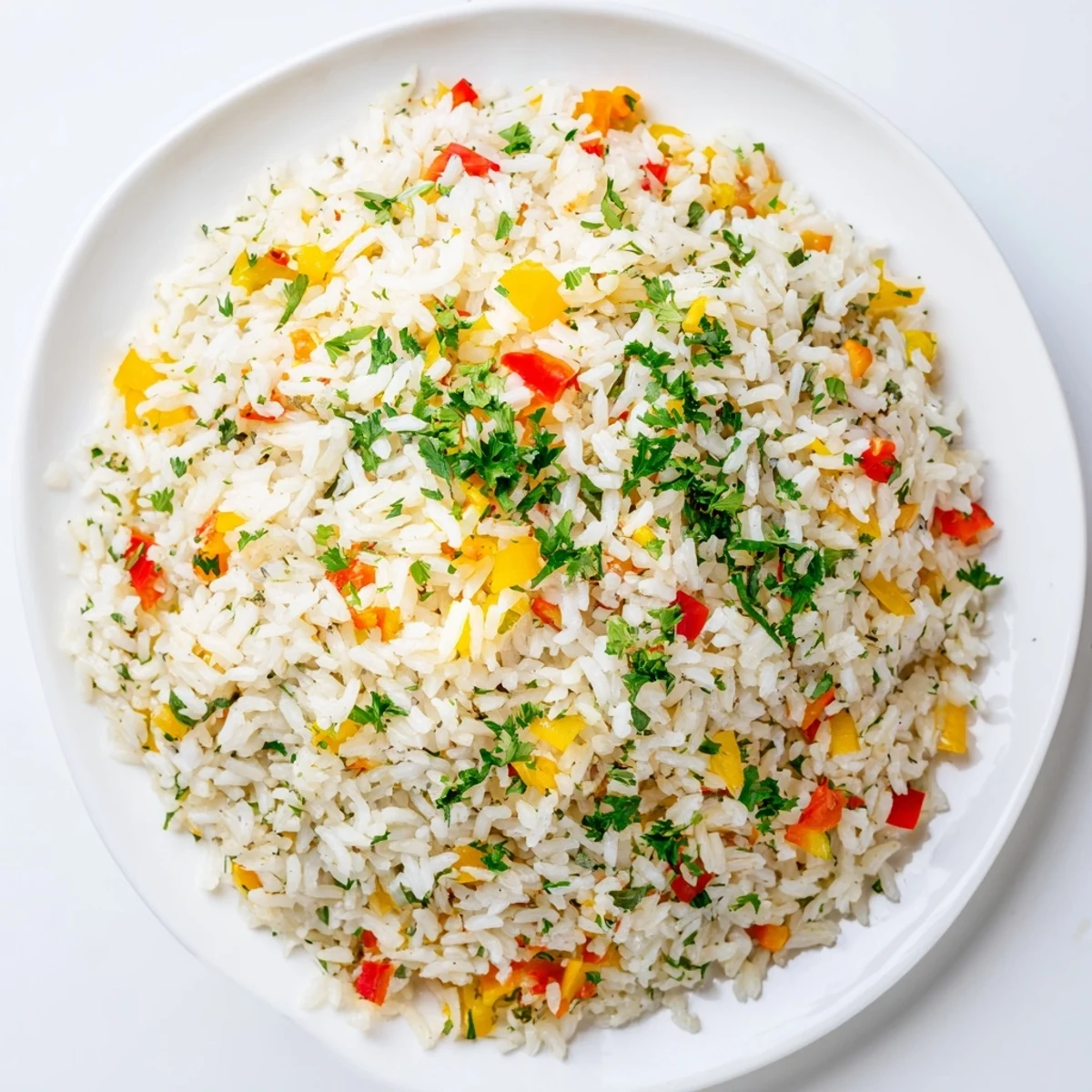 Bright, colorful Creole Rice Pilaf with peppers and onions garnished with fresh parsley in a white bowl.