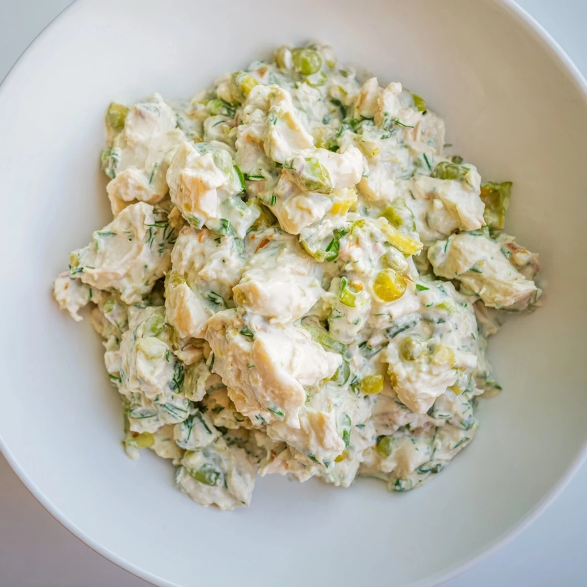 A bowl of creamy Remoulade Sauce with Crab Meat, flecked with fresh herbs and capers, served chilled for dipping.