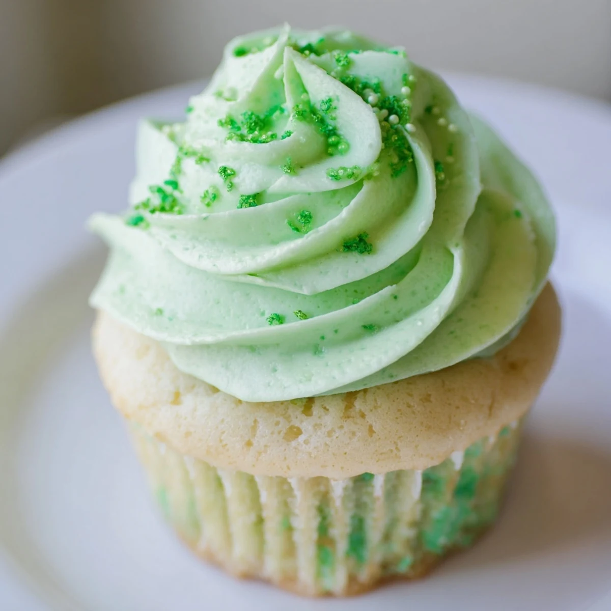 Shamrock Shake Cupcakes with piped mint frosting and visible vanilla cake crumb for St. Patrick’s Day.