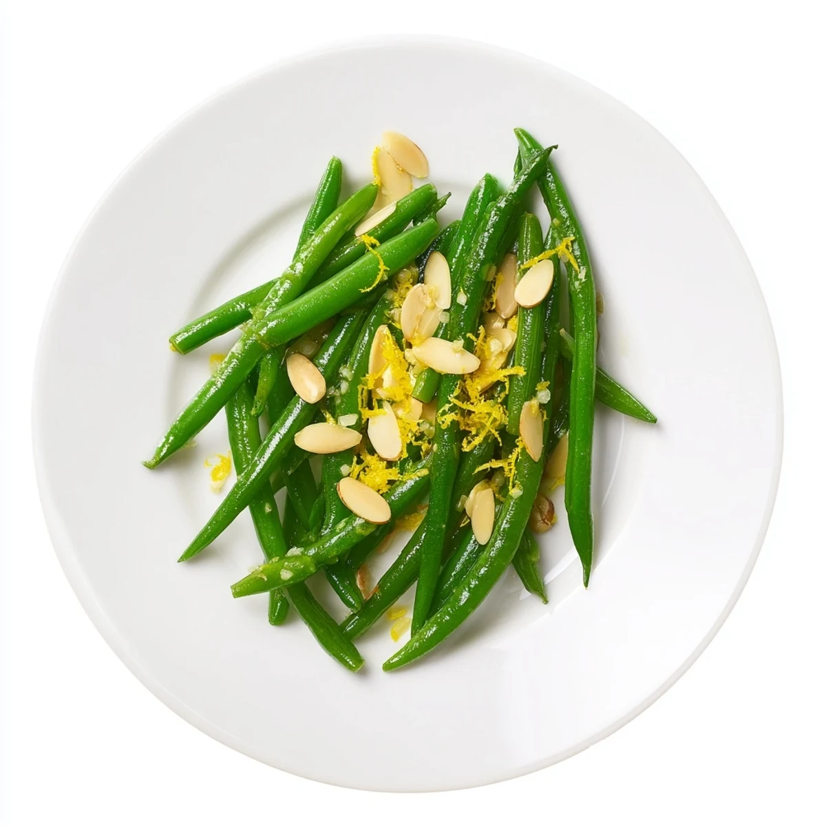 Fresh green beans with toasted almonds and lemon, garnished on a white plate for a bright side dish.