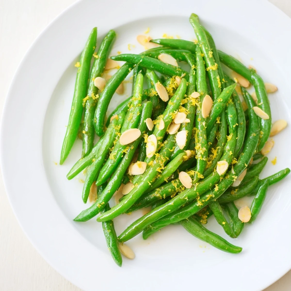 Crisp-tender green beans with toasted almonds and fresh lemon juice, a vegetarian side perfect for pairing with roasted potatoes at dinner.