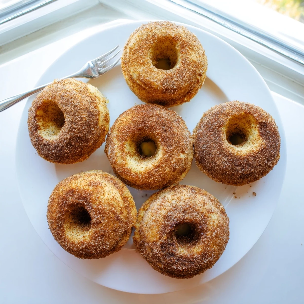 Warm Delicious Baked Cinnamon Sugar Donuts You Cant Resist paired with a steaming mug of coffee on a rustic table.