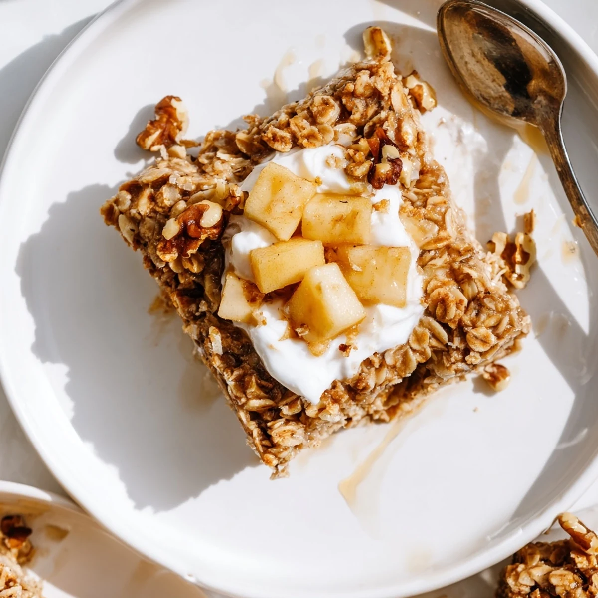 This baked apple oatmeal with Greek yogurt features a warm, golden-brown oat base and spiced apples.