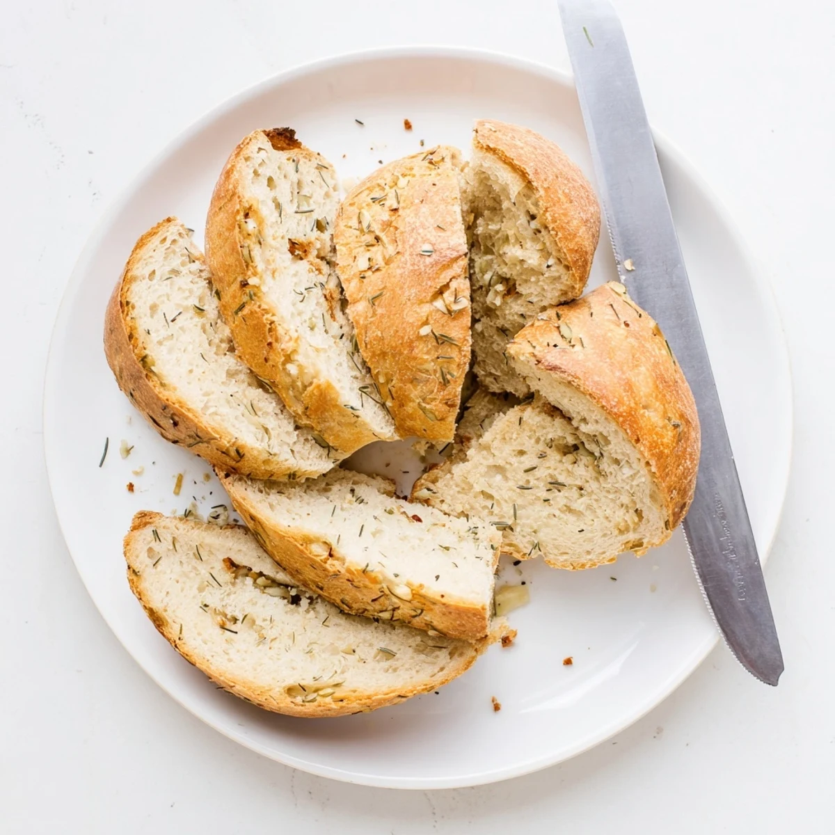 A rustic No Knead Dill Gouda Artisan Bread loaf rests on a wire rack, steaming slightly, ready for soup.