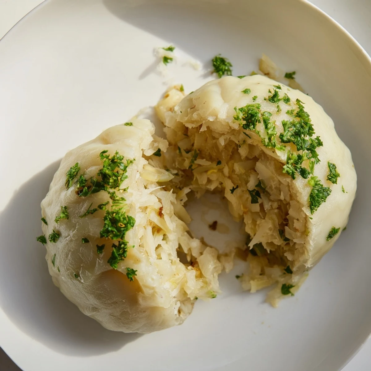 Soft and fluffy German Cabbage Dumplings simmered in broth, ready to be enjoyed as a comforting vegetarian main dish.