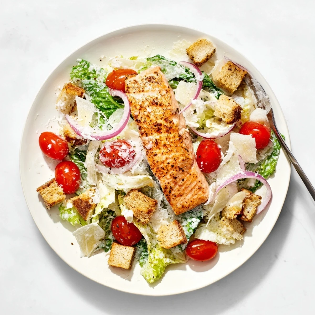 Freshly tossed Caesar salad featuring succulent grilled salmon, bright cherry tomatoes, and shaved Parmesan.  