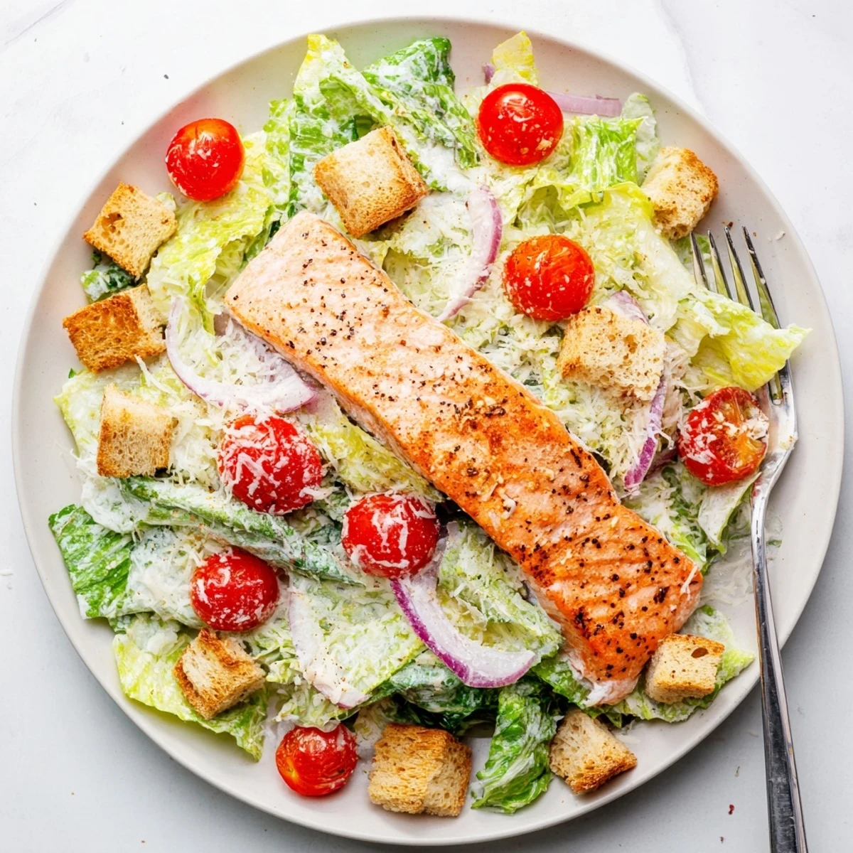 Healthy salmon Caesar salad served on a plate with golden grilled fillet and tangy dressing.