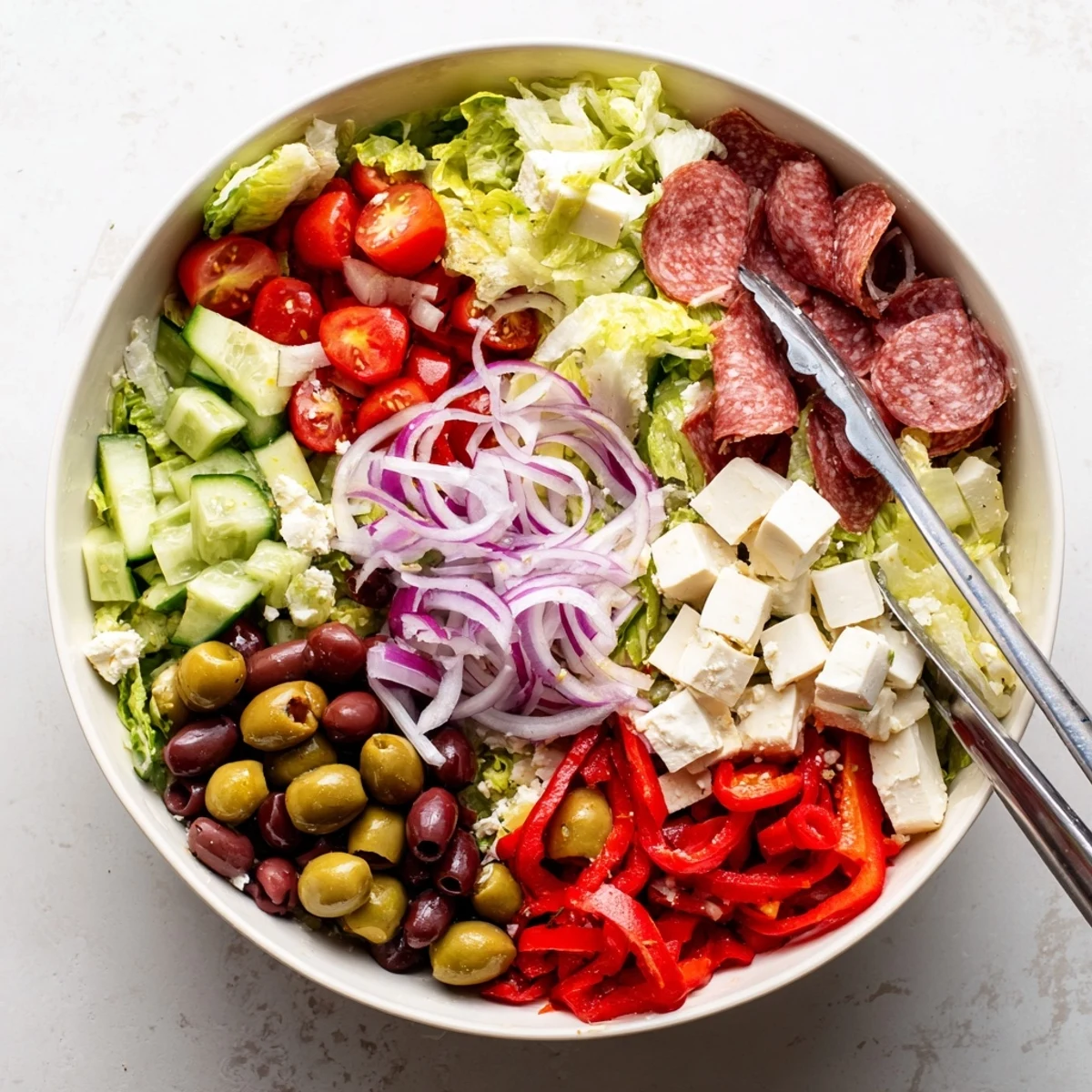 Fresh Italian chopped salad featuring crisp romaine, tomatoes, pepperoncini, cubed mozzarella and savory salami strips