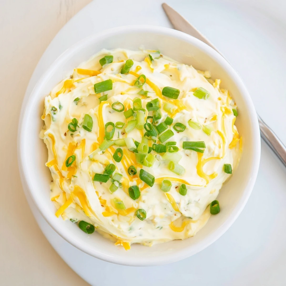 Creamy savory pretzel dip topped with fresh chives served alongside warm soft pretzels