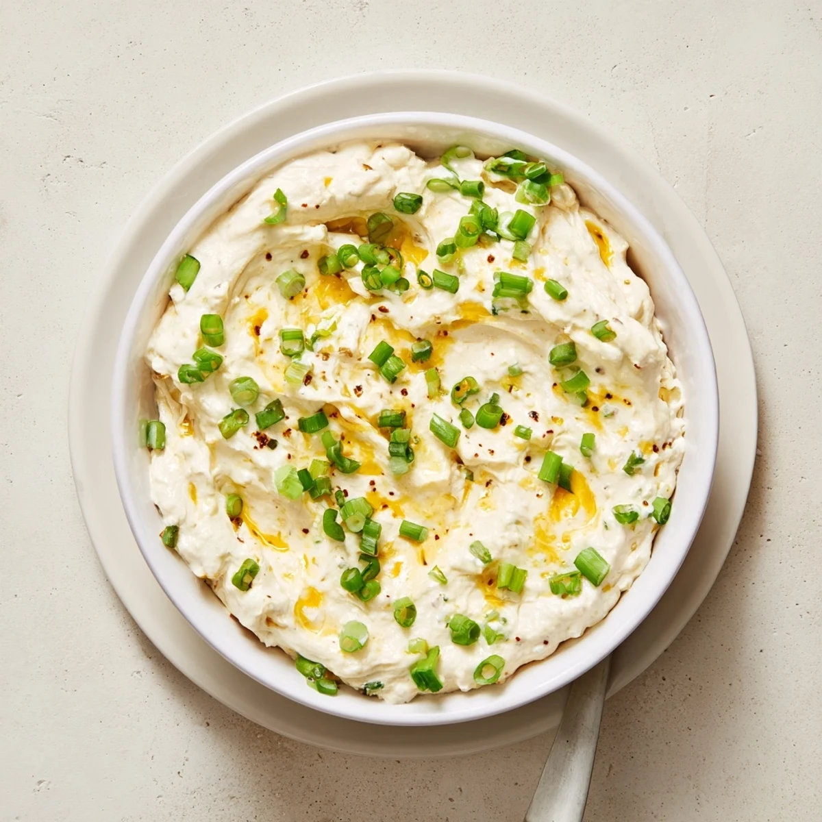 Golden sharp cheddar cheese dip with Dijon mustard in a white serving bowl
