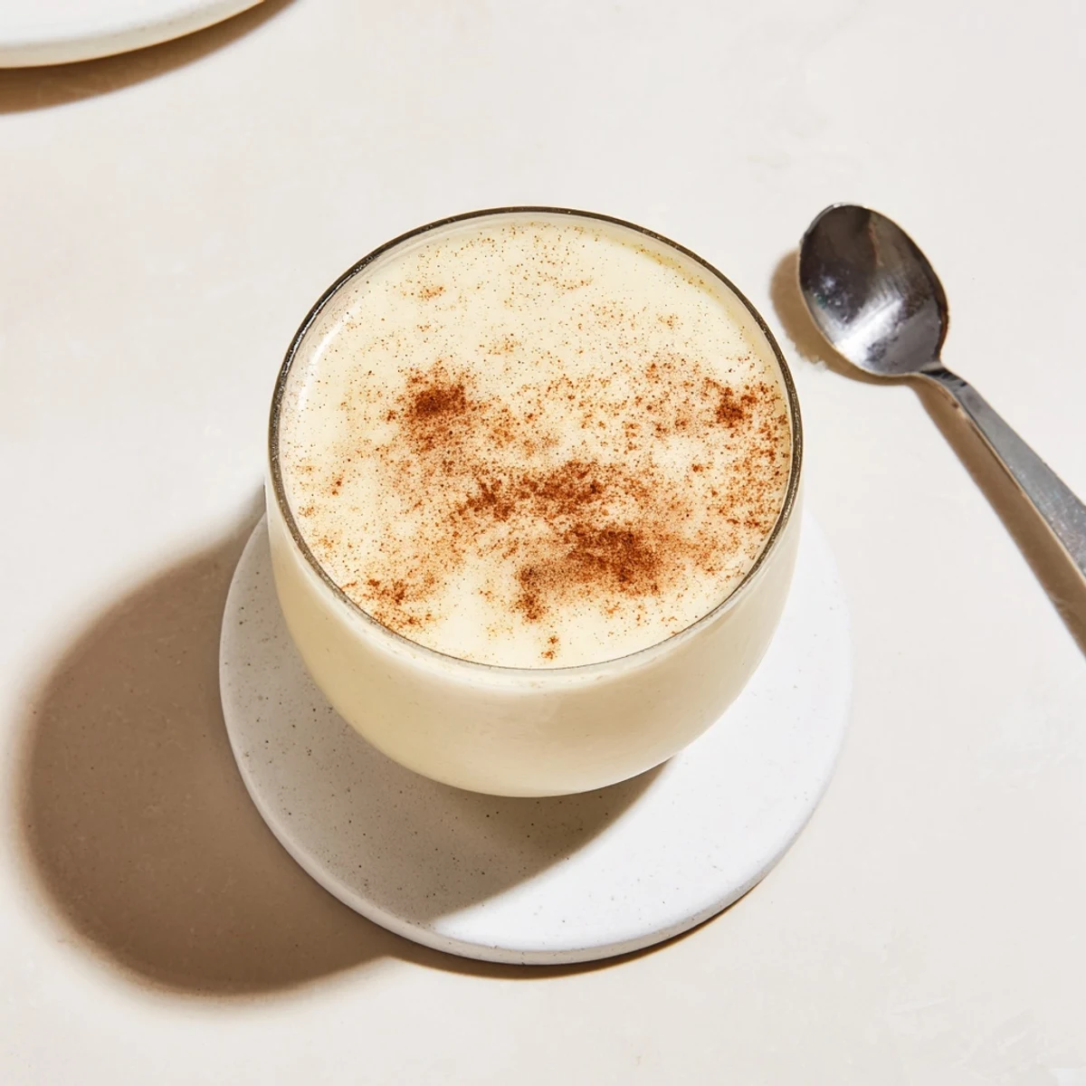 Golden blended Greek yogurt banana smoothie served in a mason jar with honey drizzle and ice cubes