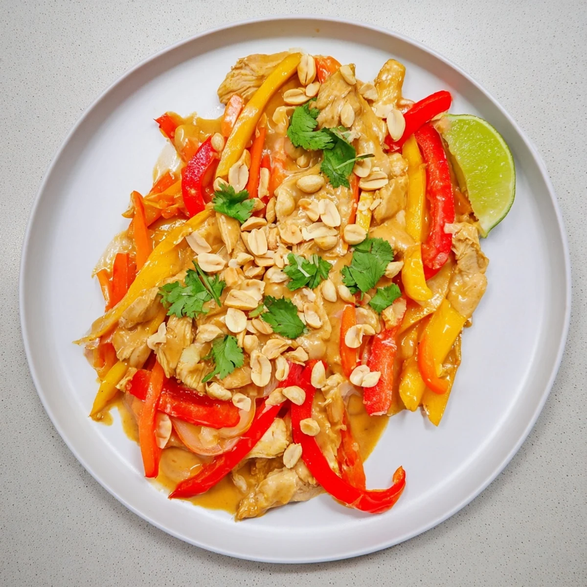 Tender shredded chicken thighs swimming in thick savory peanut butter sauce served over fluffy white jasmine rice