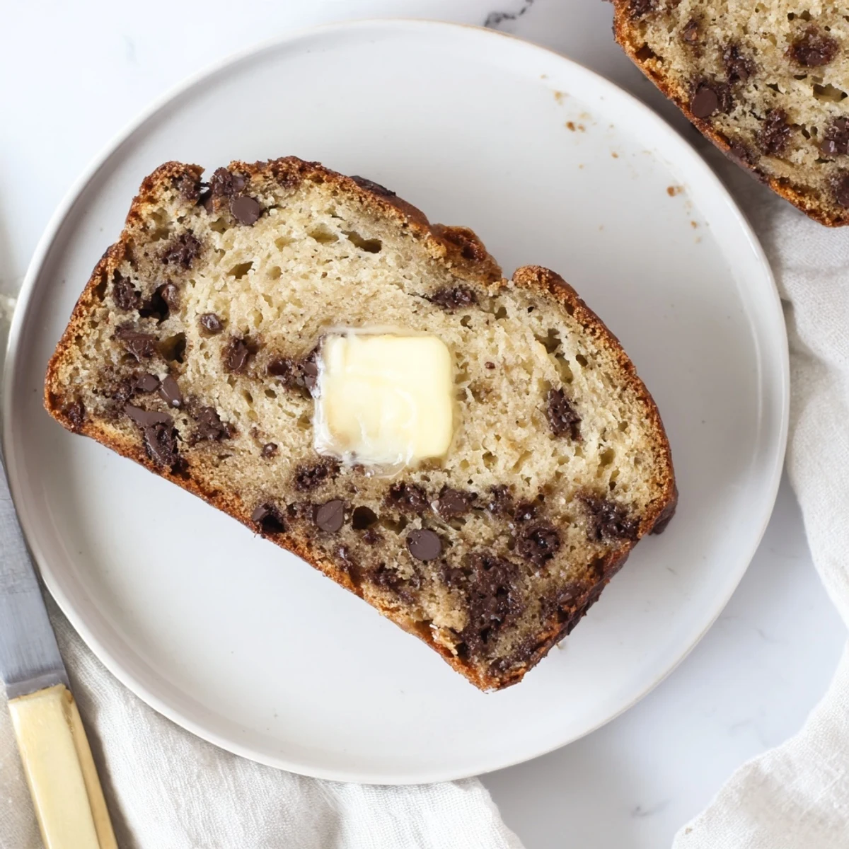 Freshly baked chocolate chip banana bread cooling on a wire rack with golden crust
