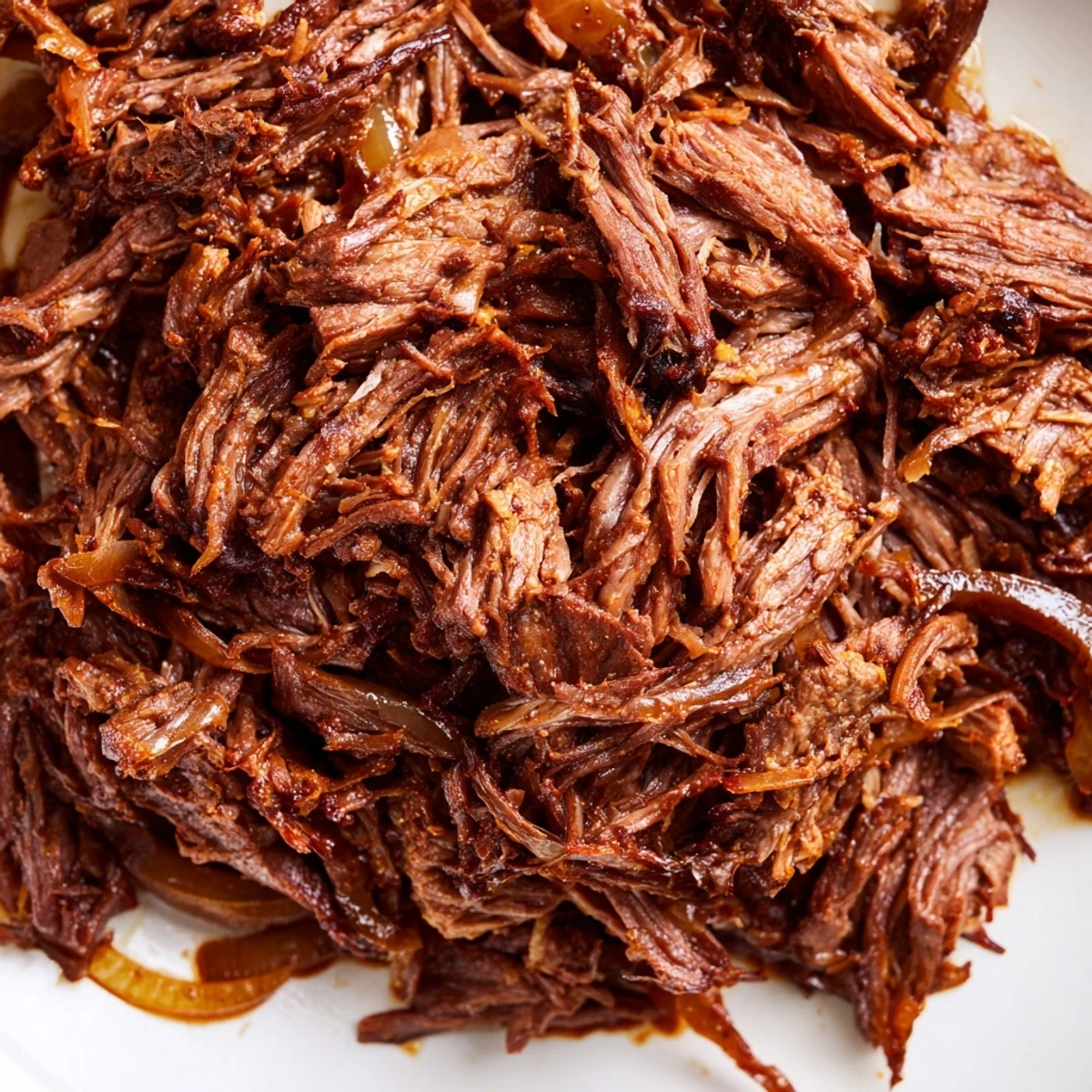 Slow-cooked shredded beef drizzled with rich juices, ready for sandwich filling