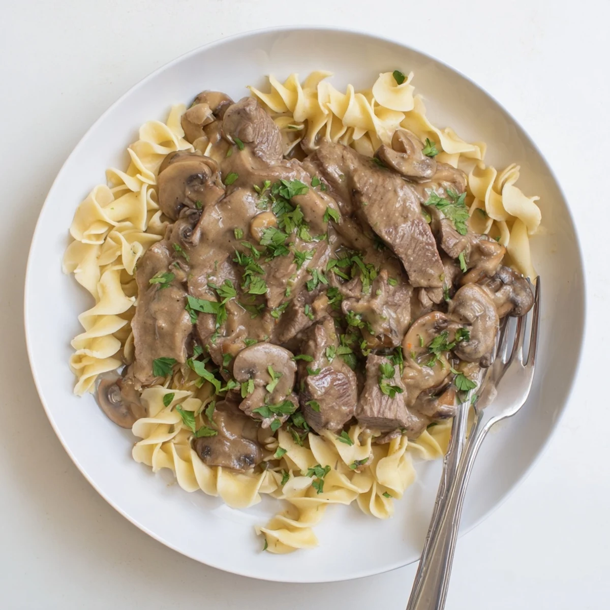 Classic beef stroganoff featuring golden mushrooms and savory beef in a velvety white cream sauce