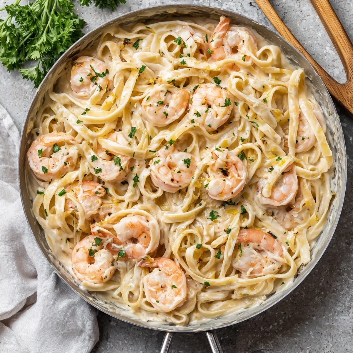 Golden fettuccine noodles coated in rich Parmesan Alfredo sauce topped with plump pink shrimp and fresh parsley garnish