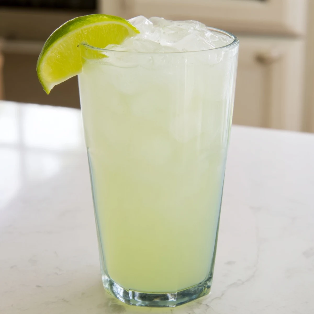 Blender pitcher filled with creamy Brazilian lemonade featuring lime pulp floating in sweetened condensed milk