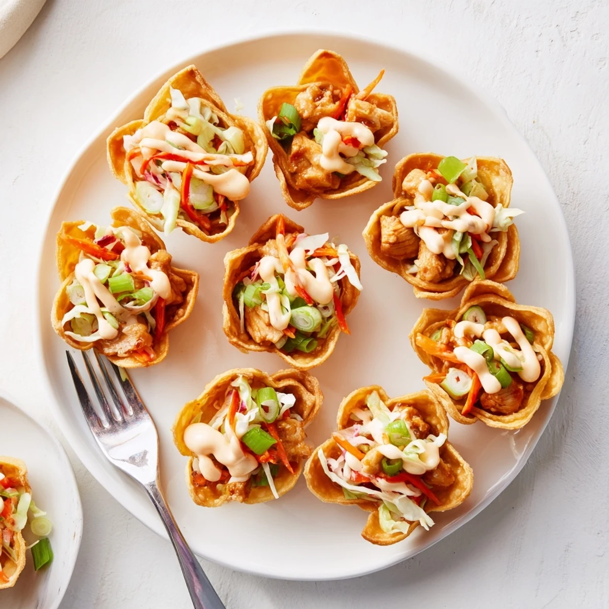 Savory chicken-filled wonton taco shells with crunchy cabbage slaw and spicy sriracha mayo drizzle