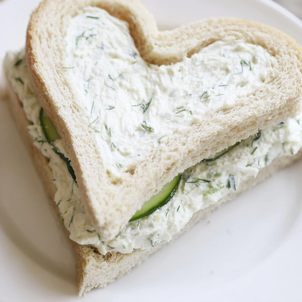 Romantic heart shaped tea sandwich board displaying three fillings including herbed butter salmon and dill cream cheese for afternoon tea gatherings
