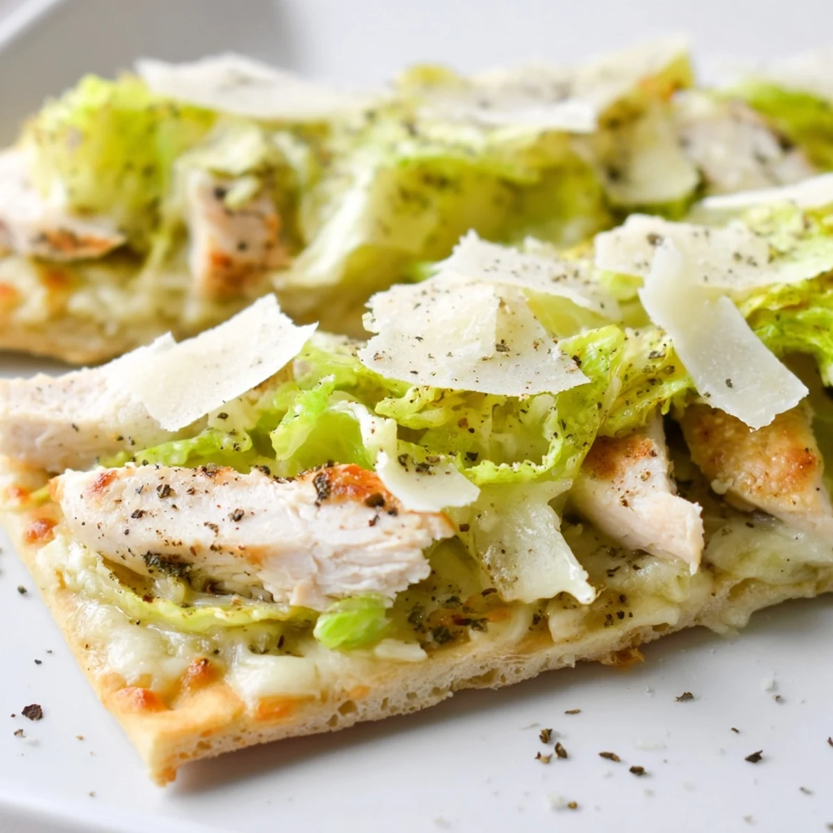 Golden Chicken Caesar Flatbread topped with melted mozzarella, crisp romaine lettuce, and shaved parmesan cheese