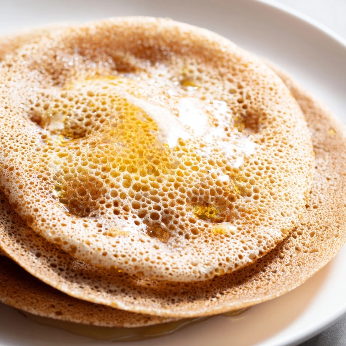 Close up of spongy baghrir Moroccan pancakes showing signature honeycomb bubble texture