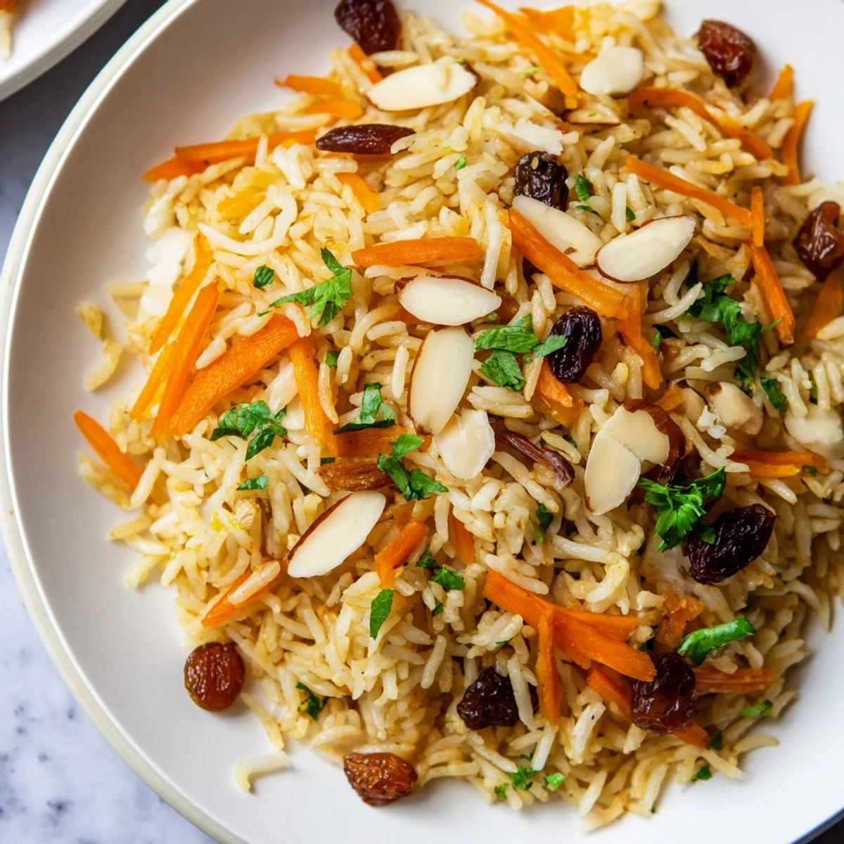 Golden Afghan rice topped with caramelized carrots, plump raisins, and toasted almonds in a colorful presentation