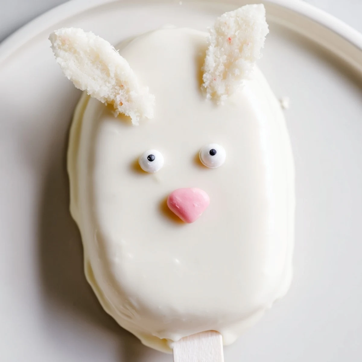 Creamy white chocolate bunny cakesicles decorated with sprinkles for festive Easter celebrations