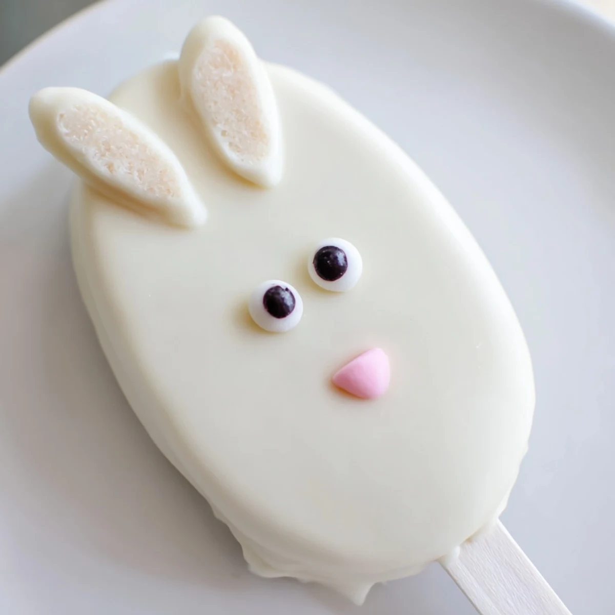 Charming bunny cakesicles dipped in smooth white chocolate with sweet fondant ear decorations