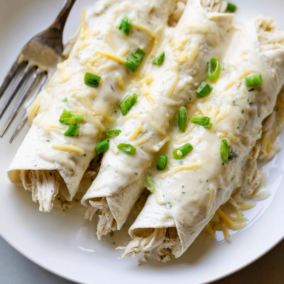 Freshly baked Creamy White Chicken Enchiladas in a casserole, steaming and comforting