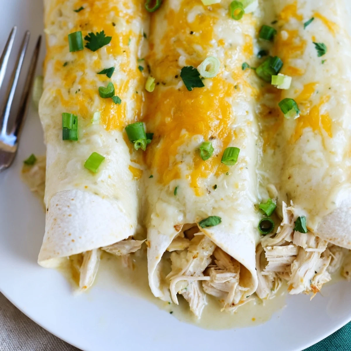 Sliced Creamy White Chicken Enchiladas served with tangy cilantro and green onion