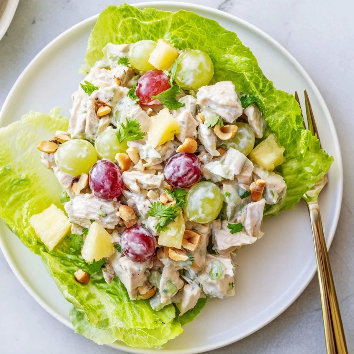 Bright Hawaiian Chicken Salad Recipe served on butter lettuce, crunchy macadamias, cilantro