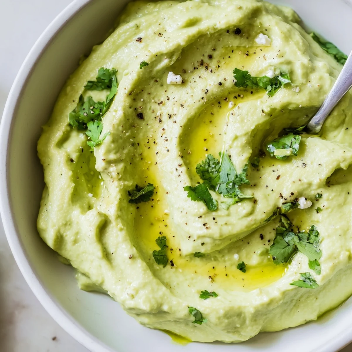 Toasted bread topped with Creamy Avocado Feta Dip, lime zest and cilantro