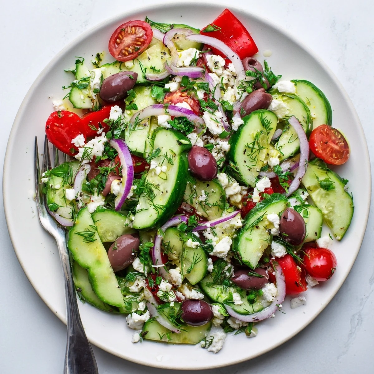 Colorful Mediterranean cucumber salad recipe featuring juicy tomatoes, crumbled feta, and herbs
