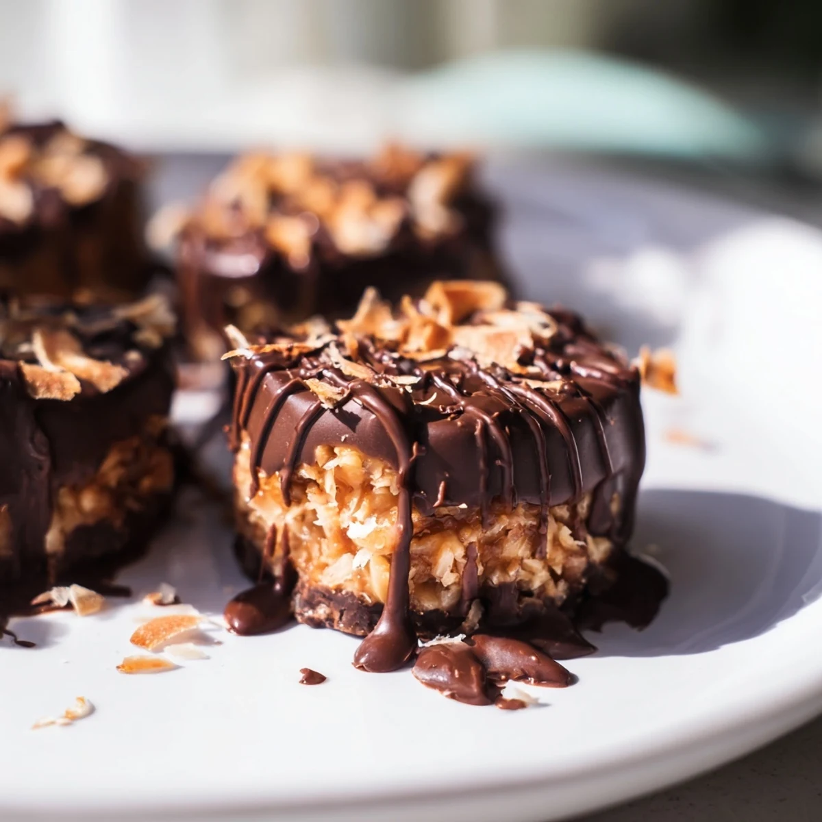 No Bake Samoa Bites featuring chocolate-drizzled coconut caramel treats on parchment paper