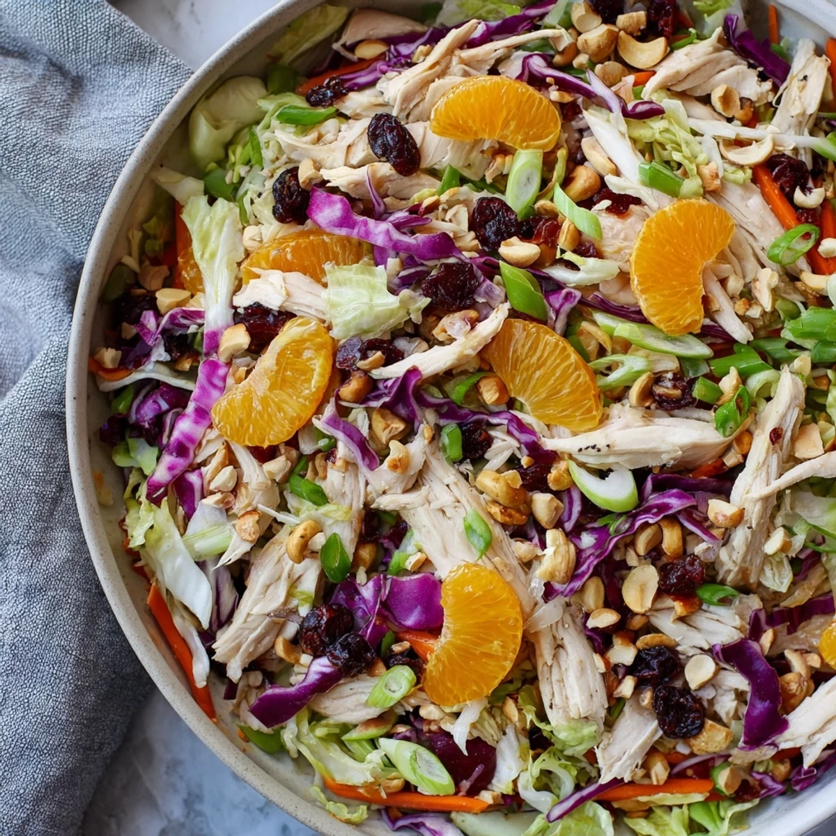 Vibrant Asian chicken cranberry salad plated with shredded chicken, crisp vegetables, and sweet cranberries