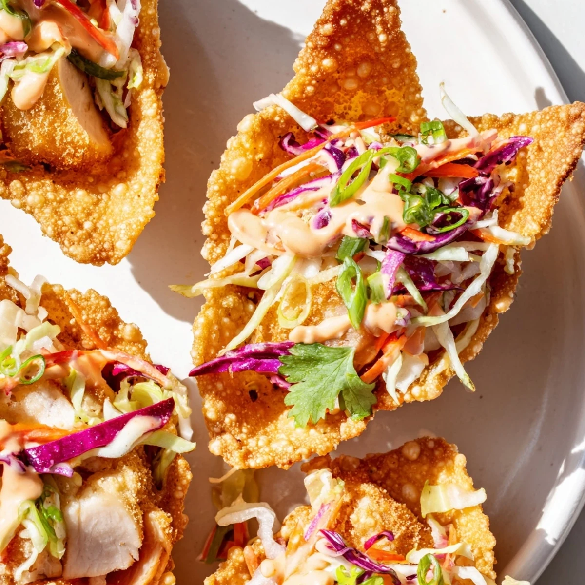 Crispy fried wonton taco shells piled high with seasoned Asian chicken and zesty spicy crema sauce