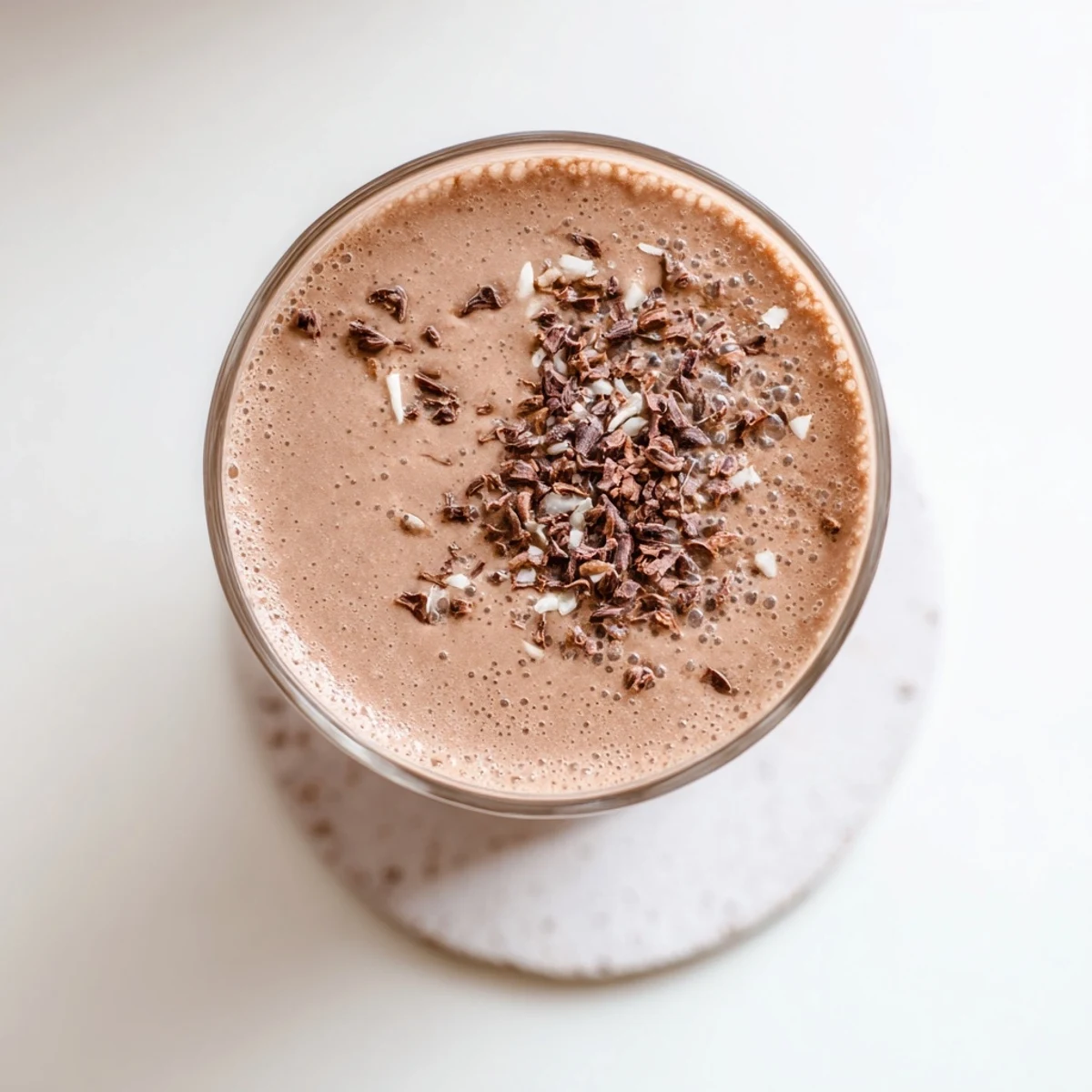 Frozen banana and raw cacao blended into a thick chocolate shake garnished with coconut flakes
