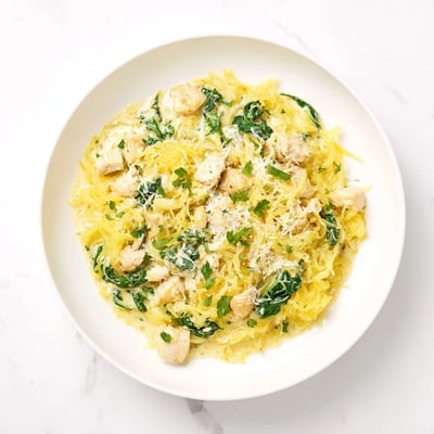 Golden roasted spaghetti squash noodles tossed with tender chicken and wilted spinach in a rich garlic Parmesan Alfredo sauce.