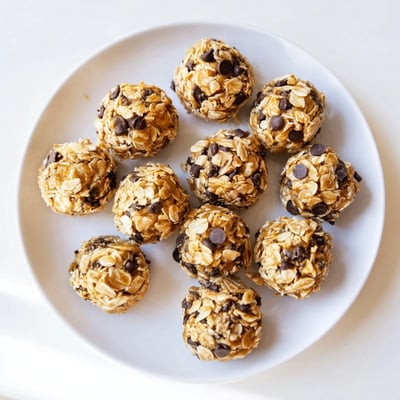 A close-up shot of moist Easy No Bake Chocolate Chip Energy Bites showing melted chocolate chips and shredded coconut textures.